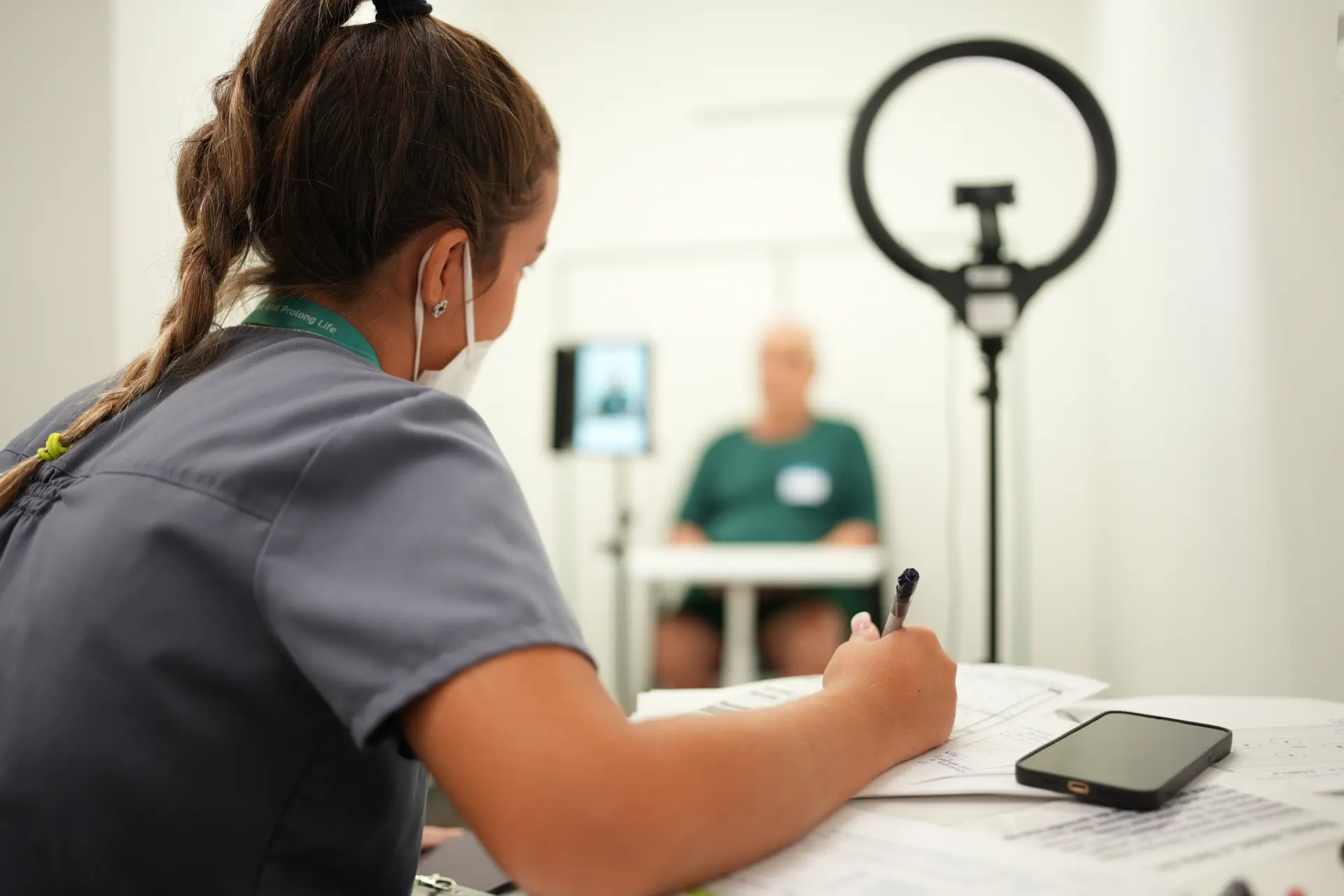 A btt clinician taking notes during a patient assessment session