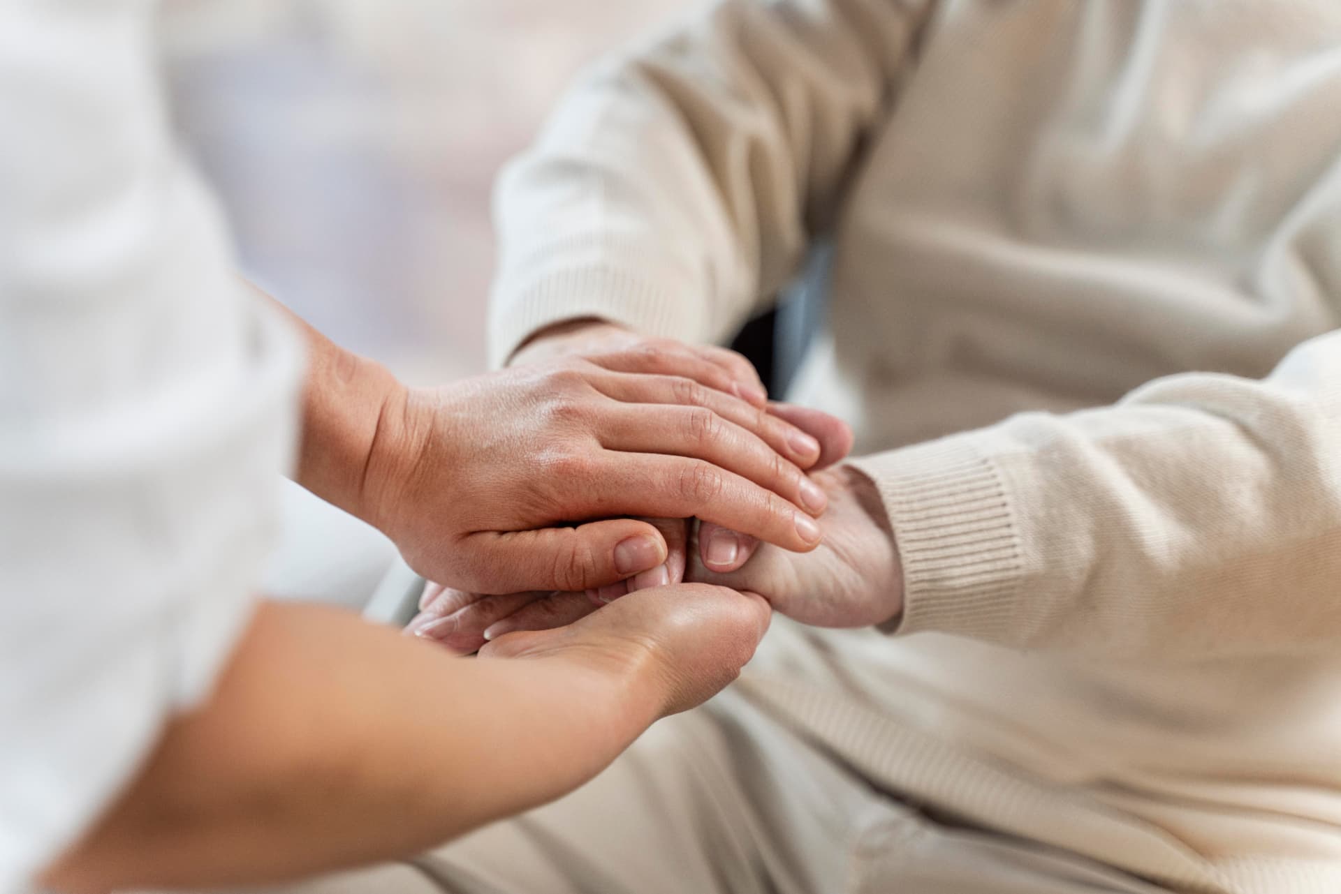 Physician holding hands with a senior patient in a compassionate care moment